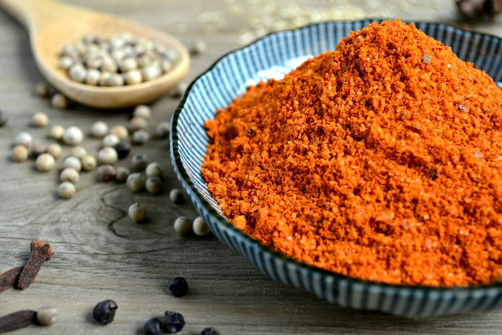 Chole masala in a blue bowl with whole spices