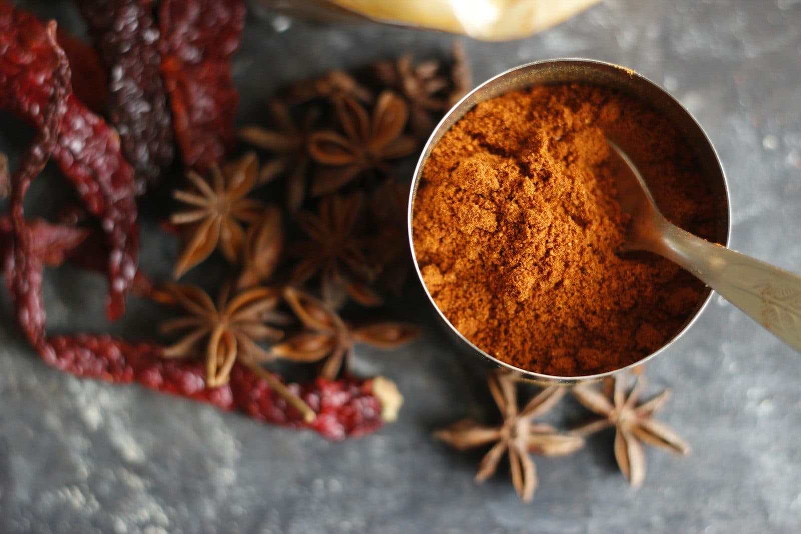 Garam masala in a brass bowl with star anise and dry red chillies
