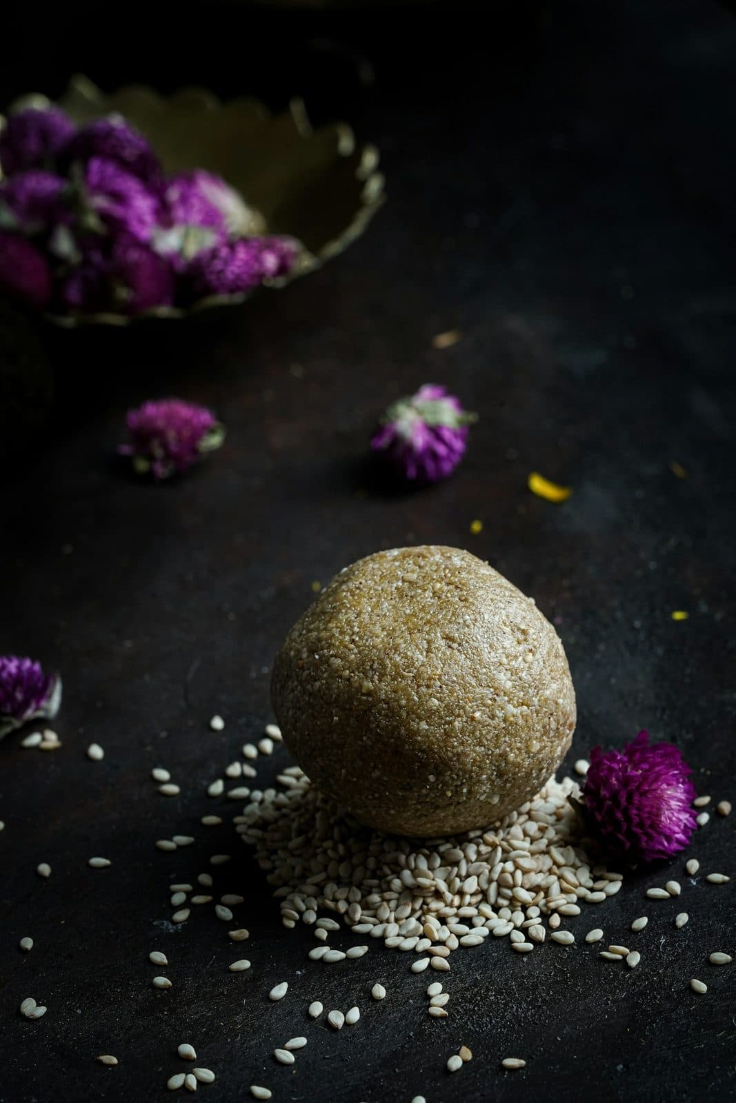 A til gud laddoo on a bed of sesame seeds